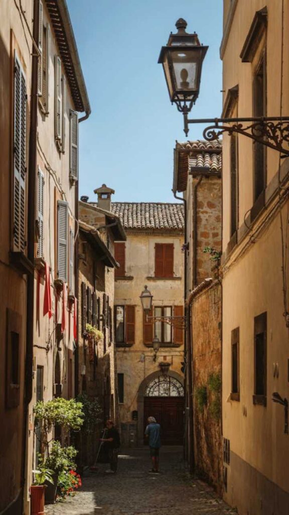 Charming narrow cobblestone street with historic houses in Assisi, Italy