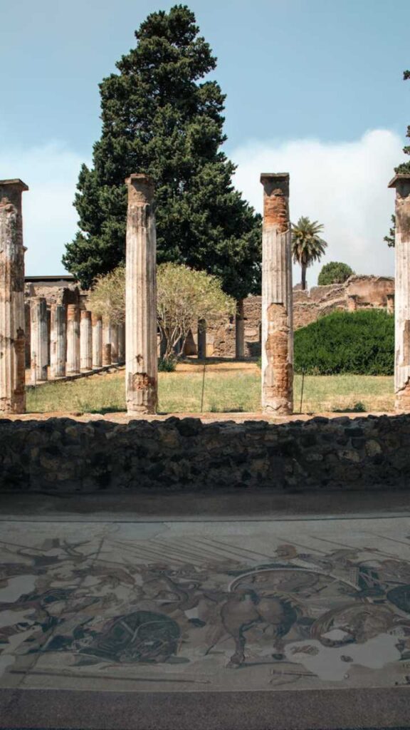Ancient columns and Roman mosaic floor in the archaeological site of Pompeii, Italy