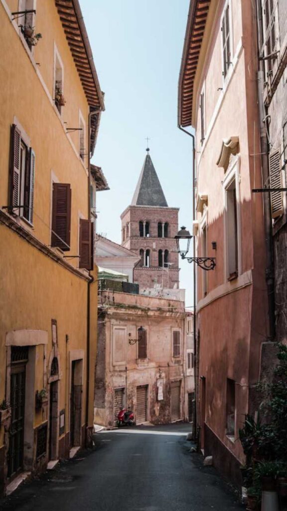 Narrow cobblestone street in Tivoli with colorful historic houses and church tower