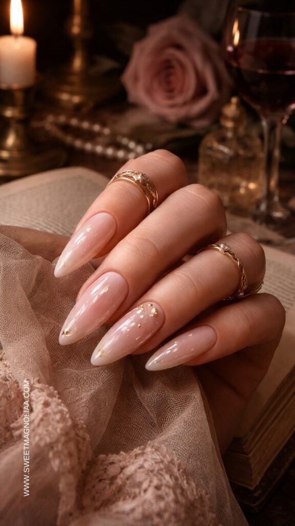 Blush pink ombre almond nails with subtle gold foil accents and glossy finish creating a minimalist luxury manicure with soft elegant sparkle.
